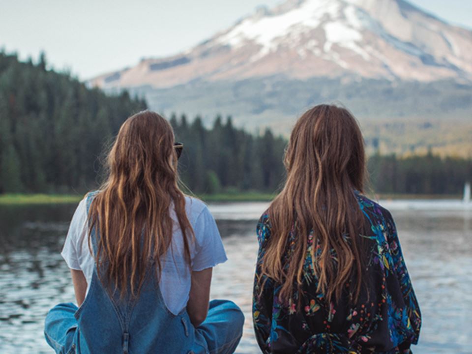 Twee studenten in de natuur met uitzicht op berg